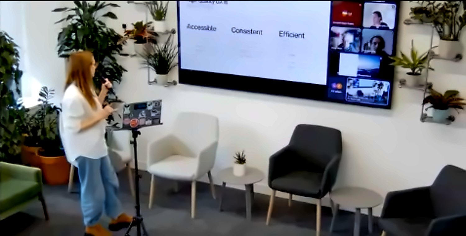 Evi presenting UX quality metrics on screen showing Accessible, Consistent and Efficient pillars